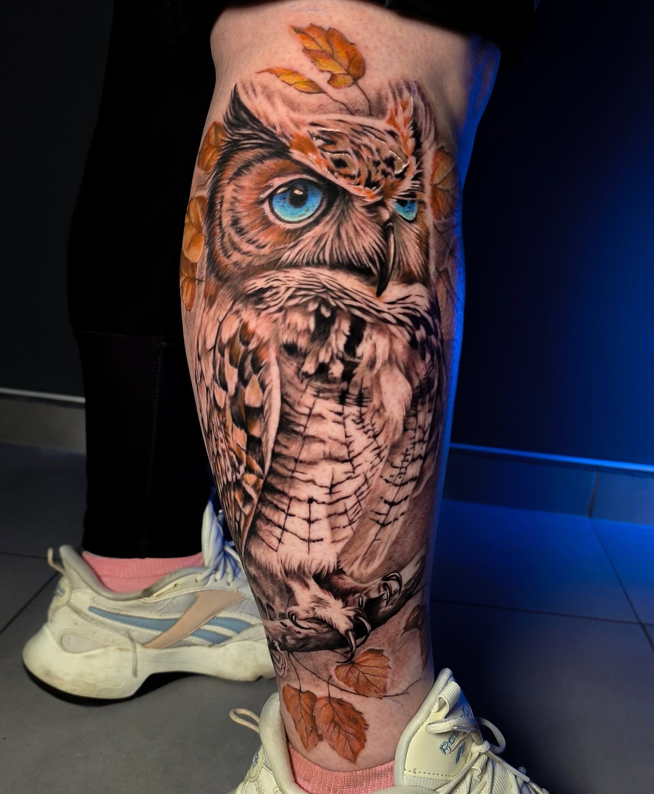 Realistyczny kolorowy tatuaż sowy na łydce — Zajawa Tattoo Żary